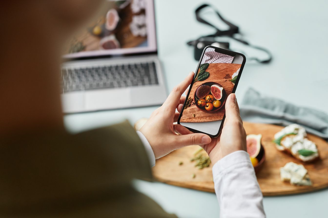 a woman taking a photo of her food using a smartphone